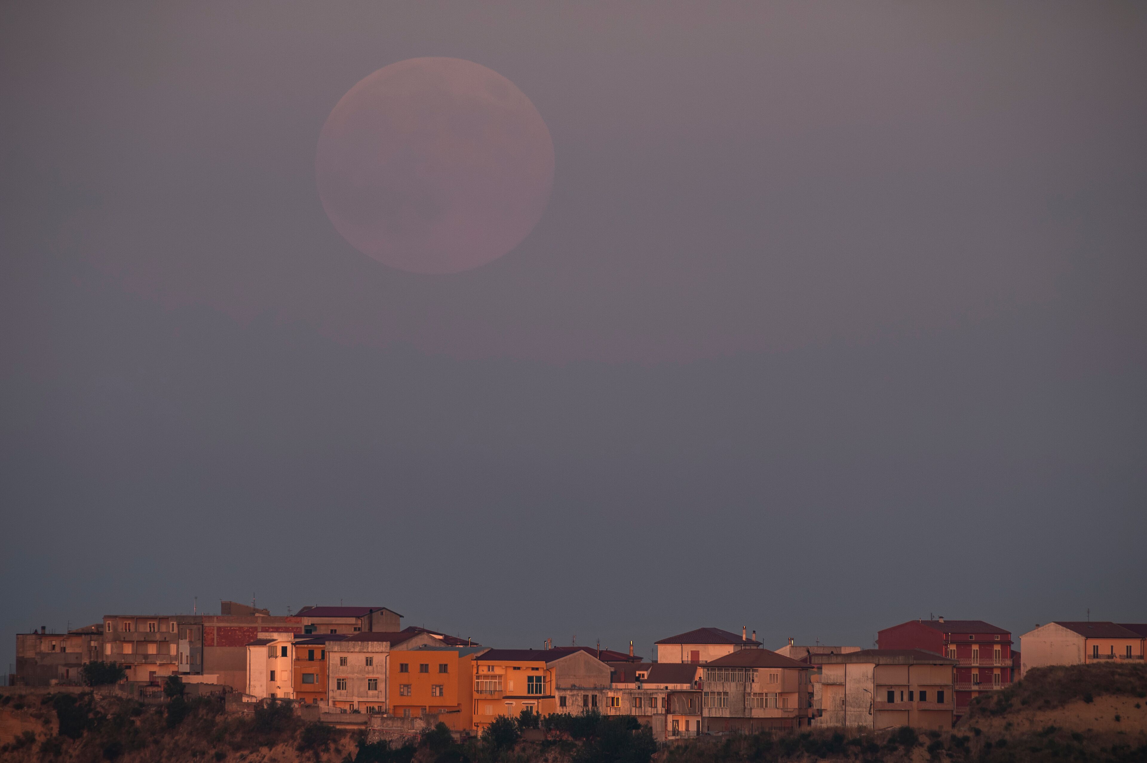 Houses of the village of Strongoli at sunset with the moon, Crotone district, Calabria, Italy