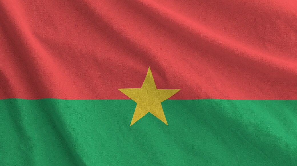 Burkina Faso flag depicted on folded wavy fabric of old cloth close up