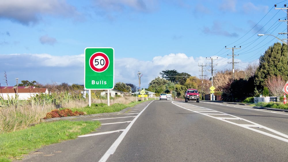 Road sign designating a fifty kilometer per hour speed zone travelling through the town of Bulls in the Rangitikei District. of New Zealand