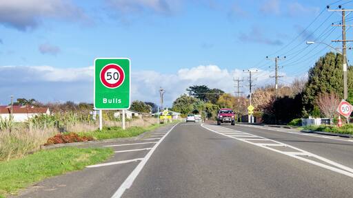 Road sign designating a fifty kilometer per hour speed zone travelling through the town of Bulls in the Rangitikei District. of New Zealand