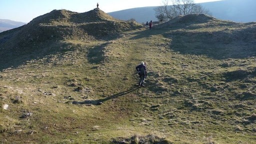 Inside Castell Dinas Human figures show the scale of this Iron Age hillfort and subsequent Norman castle site.