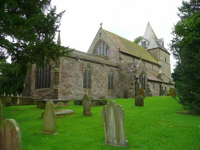 A historic church with a prominent steeple and a graveyard in front.