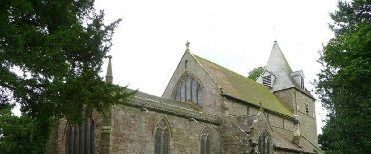 A historic church with a prominent steeple and a graveyard in front.