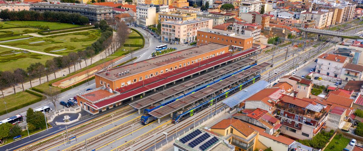 A train station with multiple tracks and a train on the platform.