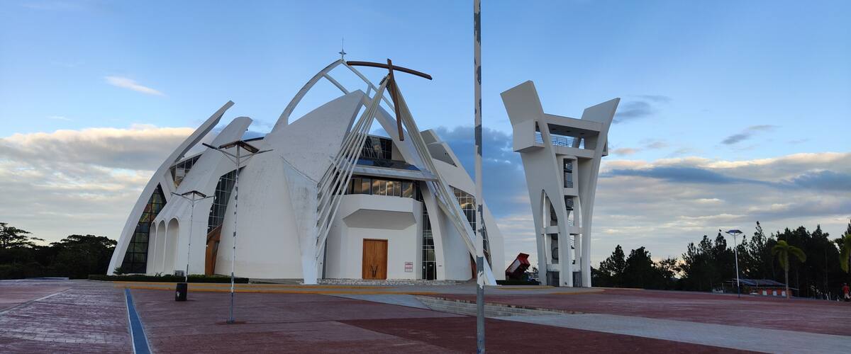 A modern architectural structure with a unique design, featuring a central dome and two symmetrical wings.