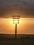 A street lamp silhouetted against a sunset with a clear sky.