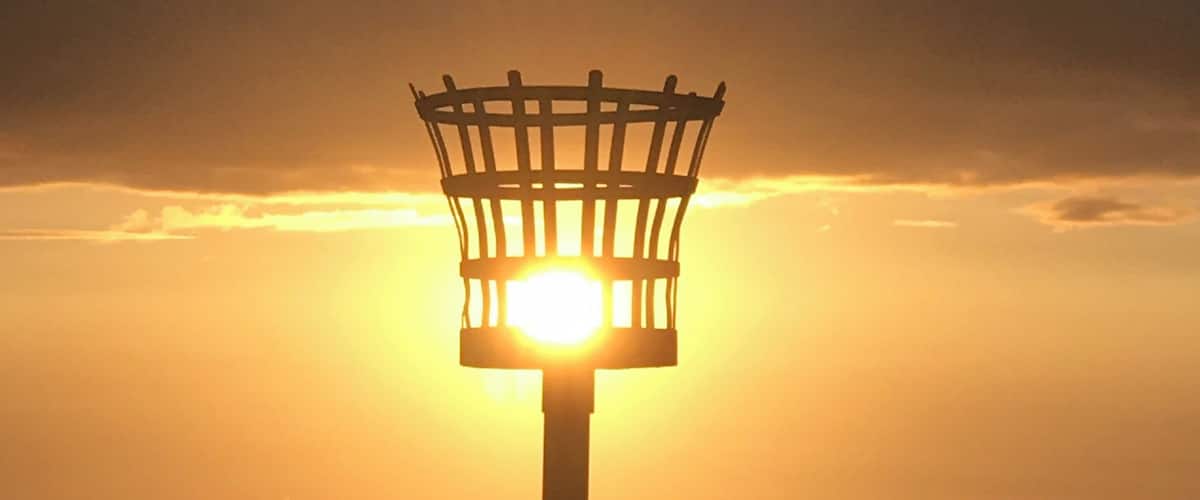 A street lamp silhouetted against a sunset with a clear sky.
