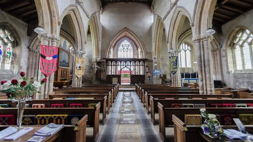 The church dates from circa 1300, and is built from ashlar with the lead roofs. The church is a cruciform plan with a west tower and spire, nave with north and south aisles, south porch, transepts, chancel and north vestry. The tower is of four stages, the two lower of circa 1300, the two upper of circa 1500. On the east side of the nave the original steeply pitched roofline is visible. The tower has ornate pinnacles and projecting gargoyles, the octagonal spire is 15th century with lucarnes, Crockets and finial. The nave has clerestory windows of three lights. There are moulded eaves with corbel heads above,and a frieze of shields, battlements and ornate pinnacles. The north aisle has an early 14th century west window and on the roof is a small bell turret,the north transept has early 14th century window of three lights. The chancel is 15th century and was restored in the 19th C. It has two large windows on both north and south sides each of three lights. There are hood moulds and grotesque animal label stops.There is a large pointed east window of five lights with perpendicular tracery. The original roofline of the chancel is visible on the east end of the nave. The south transept was probably remodelled in the 15th century from a detached lady Chapel built circa 1275. The west side of the transept has 14th century windows with head label stops. The porch is 14th century and has 15th century ornamentation, it has projecting gargoyles and ornate pinnacles. It contains stone benches and a corbel that once supported a roof, one is dated 1631. The 14th century west door has foliated capitals with elaborate finials. The nave has three bays, with piers from circa 1300. The south wall of the south transept has three 13th century sedilia and two aumbries. The chancel arch is from the 14th century and has caryatid figures. There is a 14th century screen which was restored in the 19th century. There is a 14th century hexagonal font with ornate Gables and pinnacles. The church contains various small 18th and 19th-century monuments. The church has recently undergone much restoration work including work to the spire, tower, bells, roof, windows and a new boiler system.