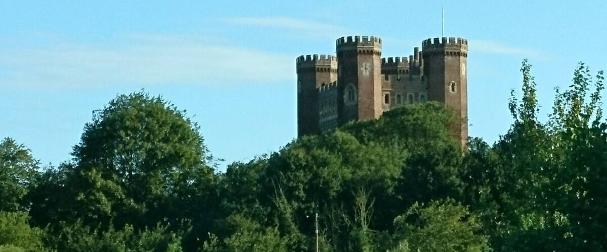 A castle surrounded by trees and a body of water.