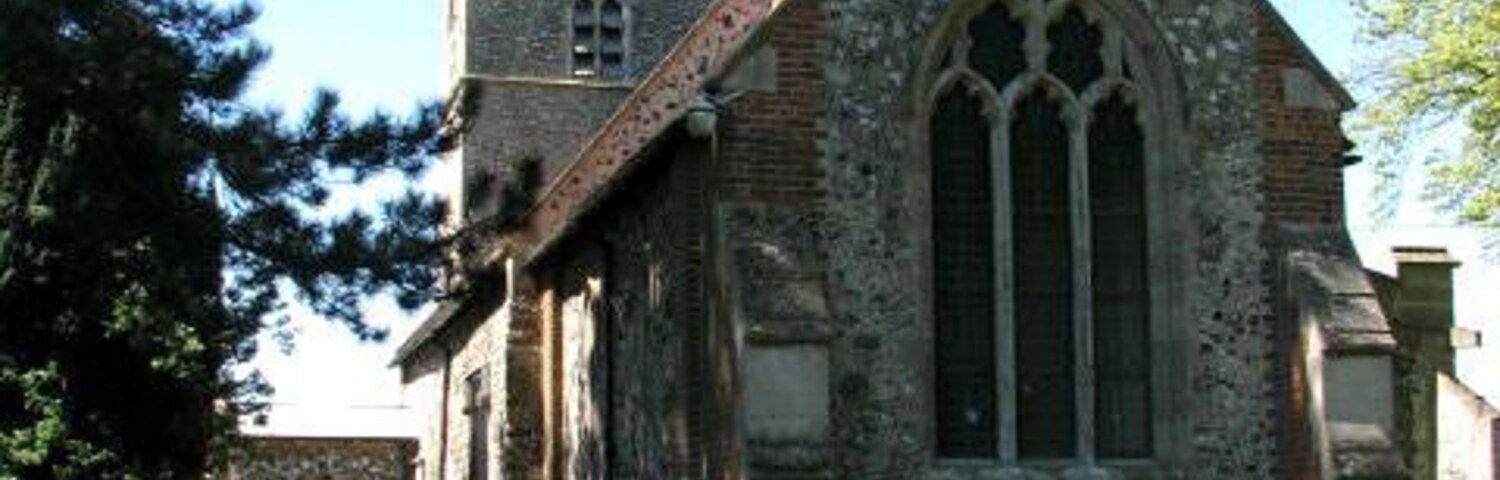 Una iglesia con una torre alta y un ventanal de arco apuntado.
