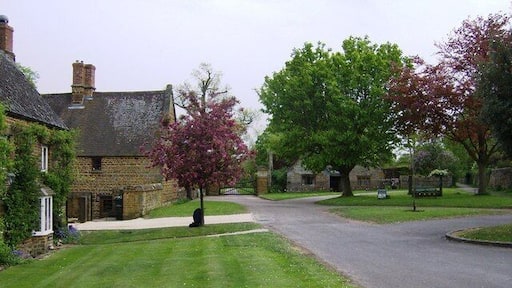 The Green, Eydon, Northamptonshire. The gates ahead are the entrance to Eydon Hall. The second house on the left is Eydon Hall farmhouse.