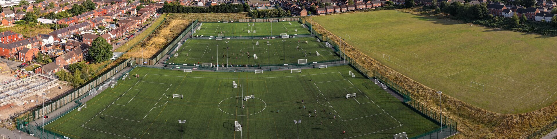Vista aérea de um grande estádio de futebol cercado por áreas residenciais.