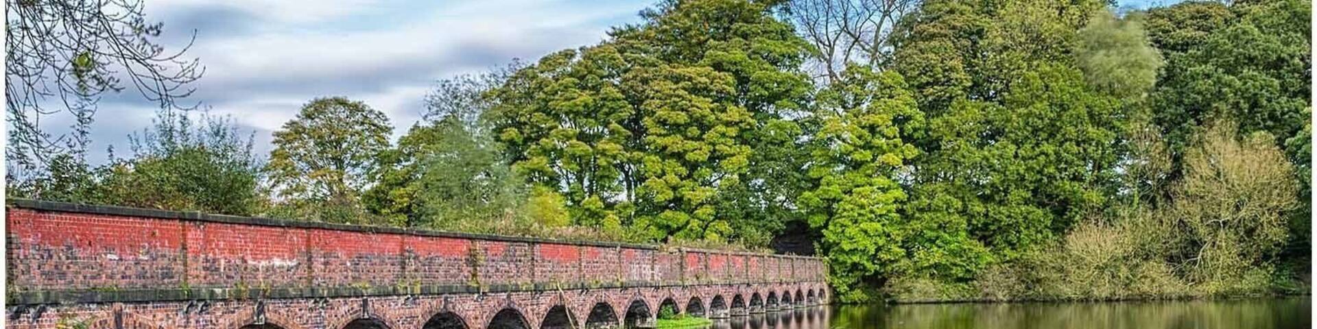 Reflections from the 19 arch bridge at Carr Mill Dam in St Helens, Merseyside