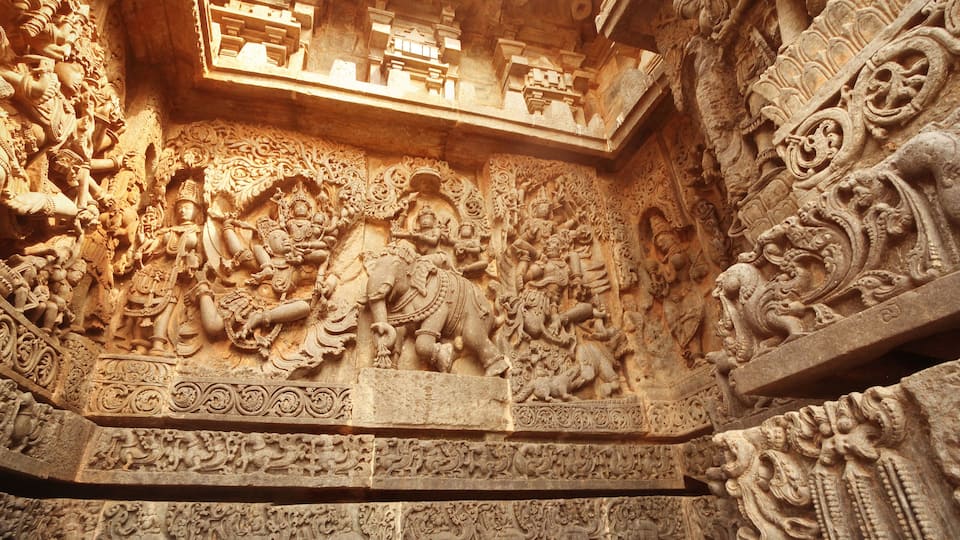 Detailed stone carvings of deities and mythological figures on a temple wall.