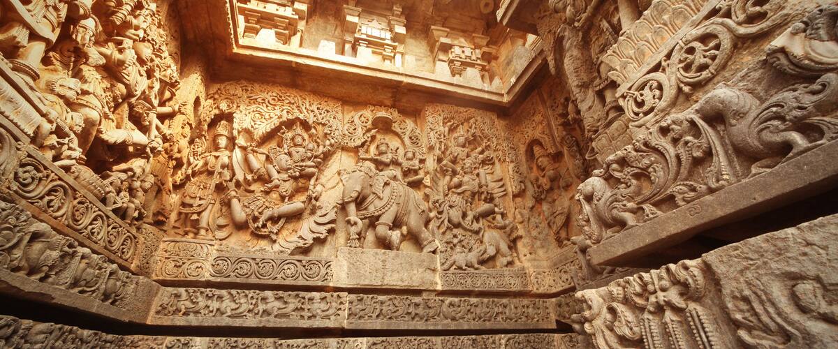 Detailed stone carvings of deities and mythological figures on a temple wall.
