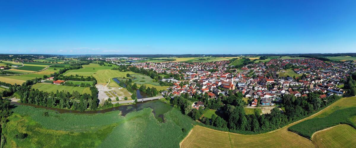 A rural landscape with a river, fields, and a small village.