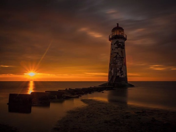 Abandoned lighthouse on Talacre Beach, North Wales. Sunset or Sunrise are the best time to photograph, especially during the summer months. The beach is tidal so check the tide times. Behind the lighthouse are sand dunes. During the summer months you can use the beach car-park, subject to tidal conditions. It's locked if there is a really high tide. The beach car park is locked after 9pm during summer months and 7pm during winter months. Check local notices of closure times. You can park in the village, local council car park, 20 pence for two hours or £2 all day.
