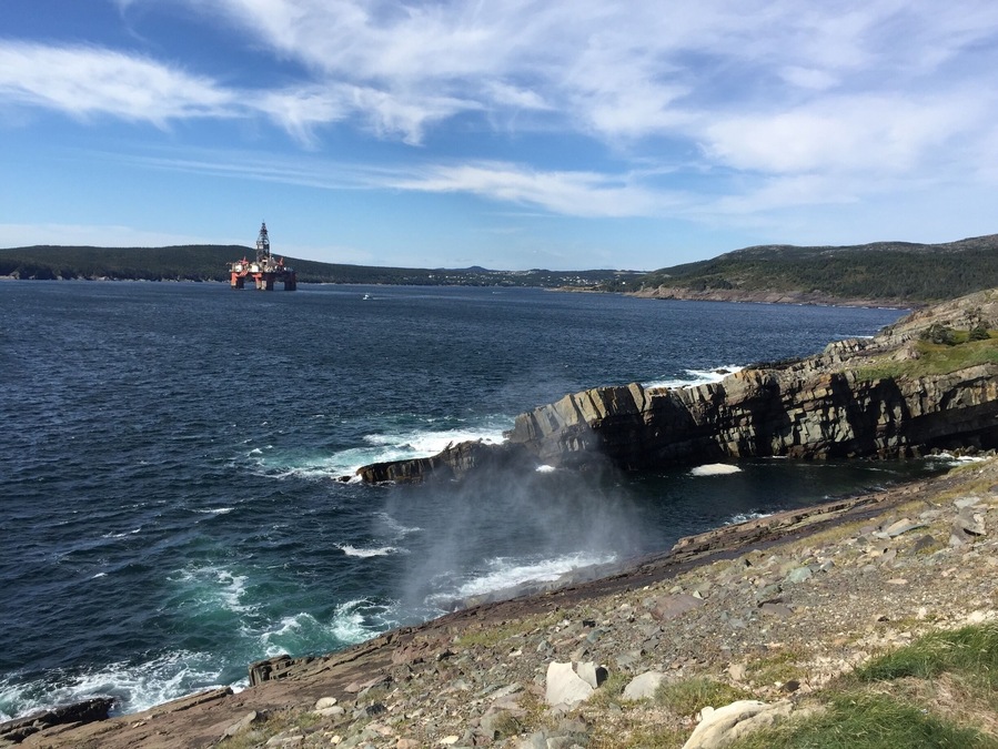 Hiking on the East Coast Trail. Sea spray on the rocks with an Oil Rig in the distance #ECT