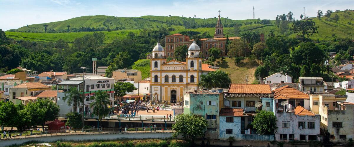 A town with a river, green hills, and a church.