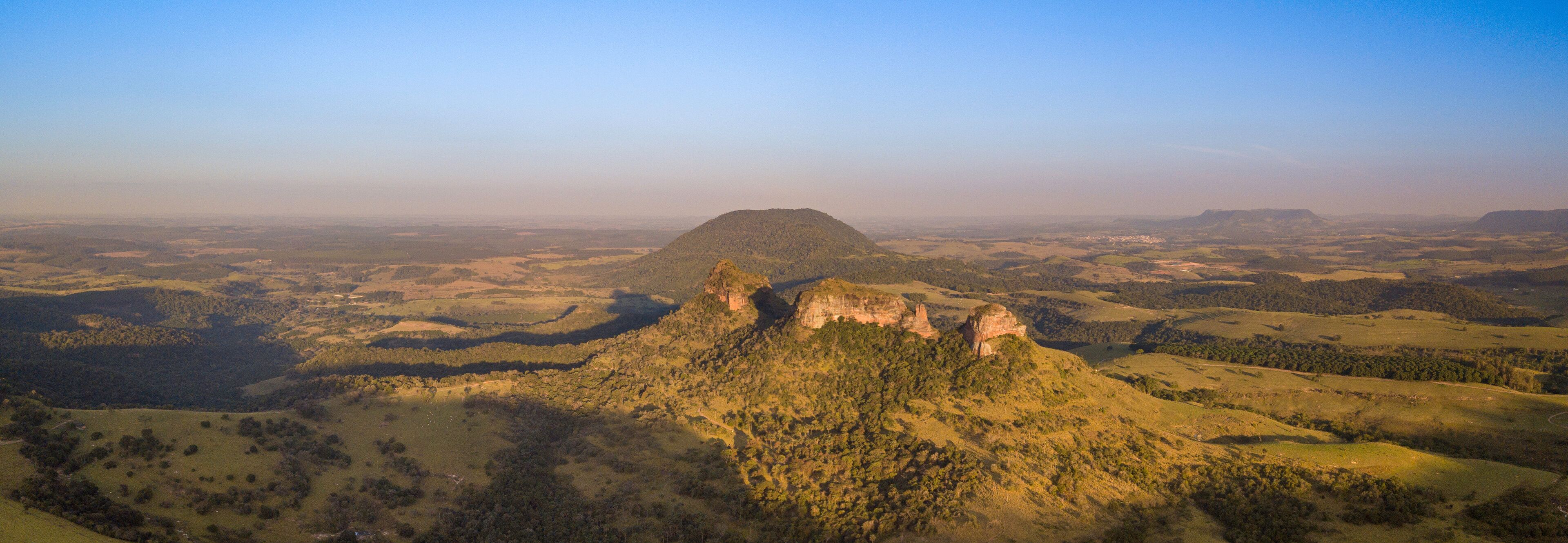 A mountainous landscape with a prominent hill and a flat-topped hill in the distance.