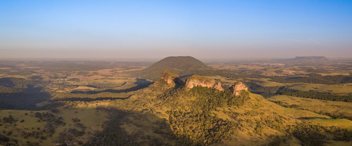 A mountainous landscape with a prominent hill and a flat-topped hill in the distance.