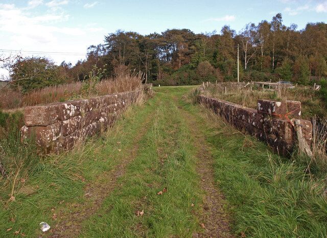 Bridge near Auchenbothie Mains Farm. This bridge carries a farm track which leads to Auchenbothie Mains Farm across the National Cycle Route 75 which uses the former Glasgow-Princes Pier railway line. For a different view of the bridge see693489.