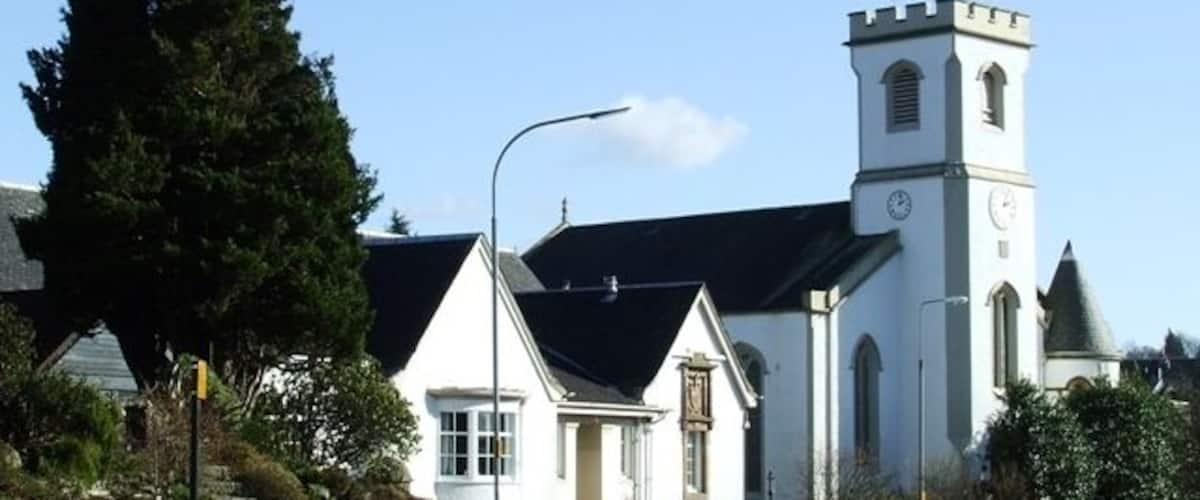 En kirke med et kirketårn og en mindre bygning ved siden af.
