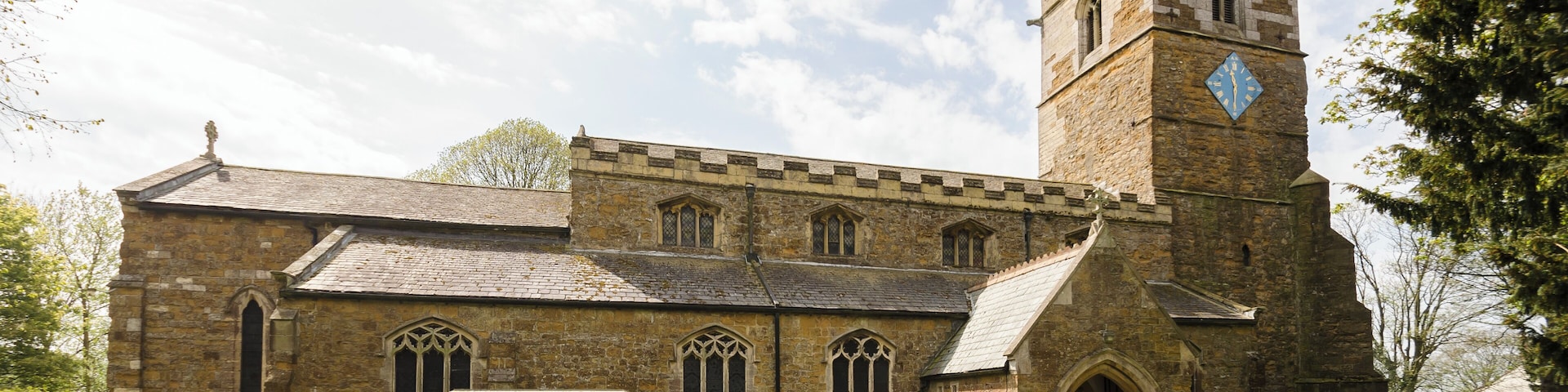 The church dates from the 11th century onwards and was rebuilt and restored in the 19th century. Certainly there was a church here in Saxon times and the lower part of the tower is probably Saxon, from around 1050. There is a west tower, nave with clerestory and north and south aisles, north porch, vestry and chancel. The tower is built in ironstone and dates from the mid-12th century. It is thought that the lower stage the tower could have been a Norman porch to the old church. The second stage is Early English and the top stage is Perpendicular. The tower has an embattled parapet with pinnacles and gargoyles. The tower arch has zigzag decoration. There are eight bells. The nave has four-bay arcades with octagonal piers and four clerestory windows either side. The chancel arch is from the 13th century. It is thought that the church may have been intended as being a cruciform shape with a crossing, or it may indeed have once been like this. The chancel was largely rebuilt in 1848 and restored in 1873. The reredos is from that date. There are several effigies of Knights set into arched tombs in the wall. There is a triple lancet east window, and stained glass from a variety of makers. The organ is by Cousans, and was installed in 1885. The rood beam is by Wilfrid Bond, erected in 1929.