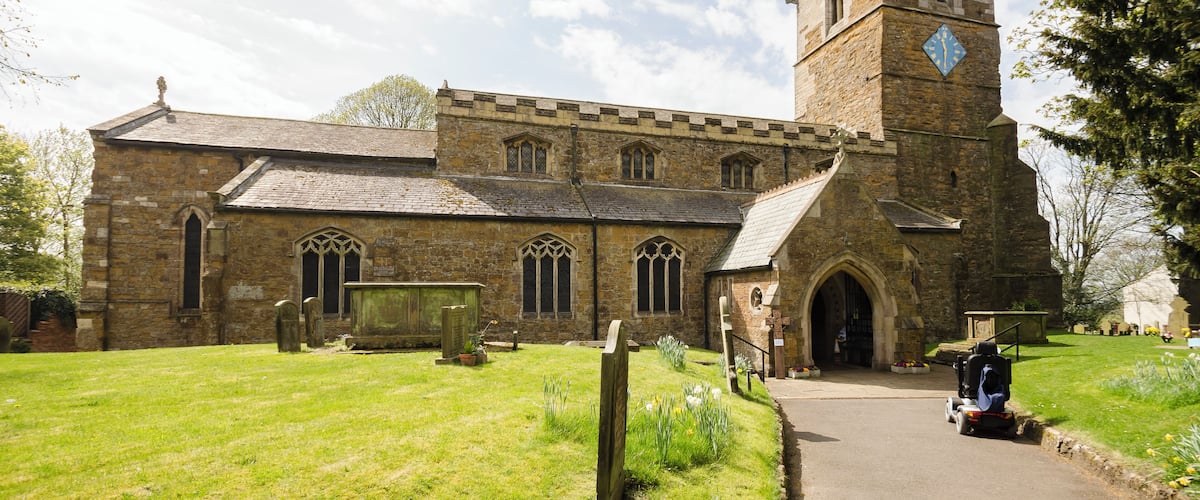 The church dates from the 11th century onwards and was rebuilt and restored in the 19th century. Certainly there was a church here in Saxon times and the lower part of the tower is probably Saxon, from around 1050. There is a west tower, nave with clerestory and north and south aisles, north porch, vestry and chancel. The tower is built in ironstone and dates from the mid-12th century. It is thought that the lower stage the tower could have been a Norman porch to the old church. The second stage is Early English and the top stage is Perpendicular. The tower has an embattled parapet with pinnacles and gargoyles. The tower arch has zigzag decoration. There are eight bells. The nave has four-bay arcades with octagonal piers and four clerestory windows either side. The chancel arch is from the 13th century. It is thought that the church may have been intended as being a cruciform shape with a crossing, or it may indeed have once been like this. The chancel was largely rebuilt in 1848 and restored in 1873. The reredos is from that date. There are several effigies of Knights set into arched tombs in the wall. There is a triple lancet east window, and stained glass from a variety of makers. The organ is by Cousans, and was installed in 1885. The rood beam is by Wilfrid Bond, erected in 1929.