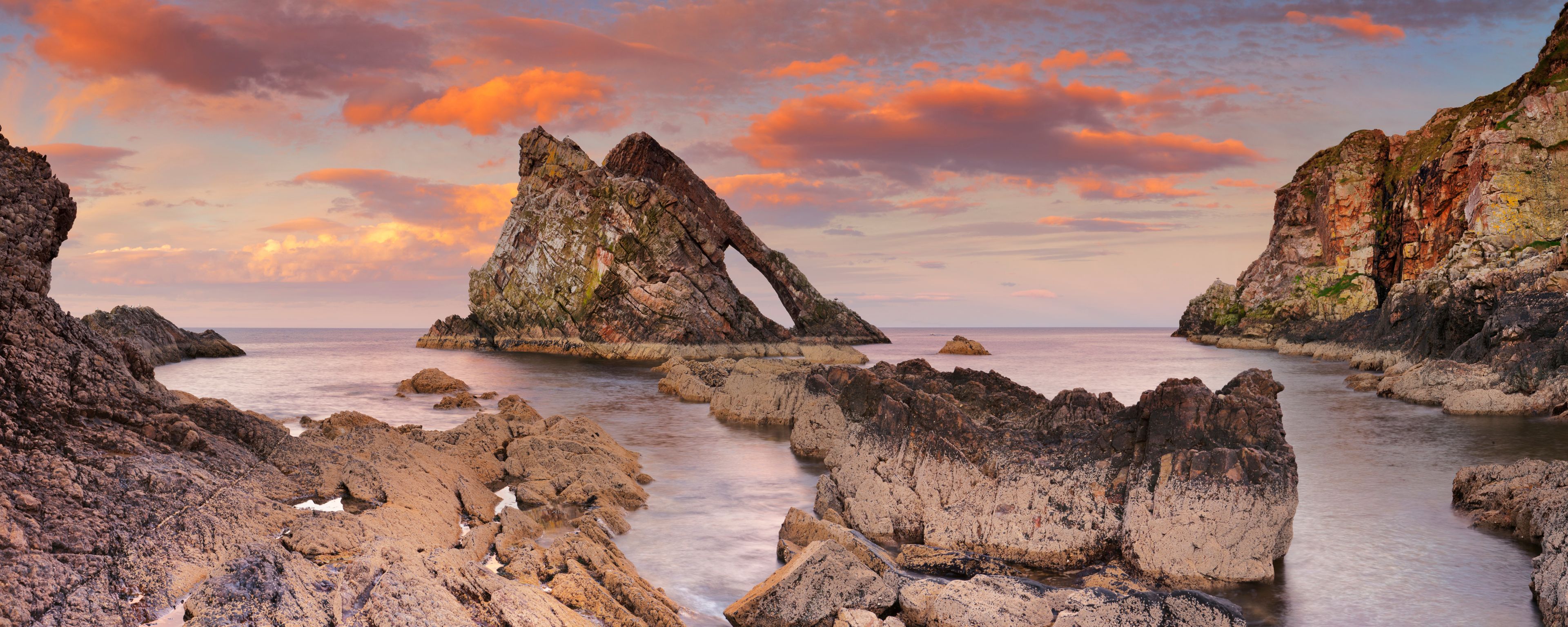 Bow Fiddle Rock, natural arch on Moray coast, Scotland, sunset