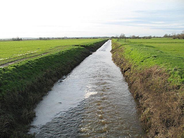 Division Rhyne and East Waste Division Rhyne is one of many drainage channels criss-crossing and draining the northern Somerset Levels. The land at this point is below 5m and prone to severe flooding. The flat area on the left is known as East Waste.