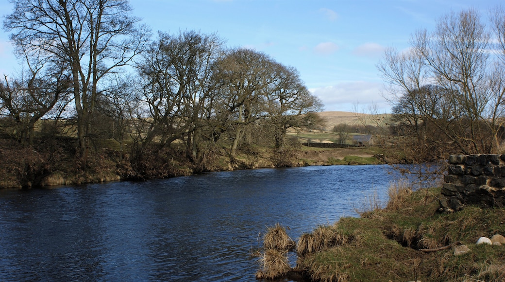 The River Wharfe The stonework in the foreground marks the start of a stretch of wall protecting the bank as the river enters a left hand bend.