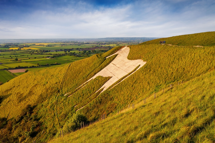 A grassy hill with a concrete structure resembling a giant letter 'A' on a slope.