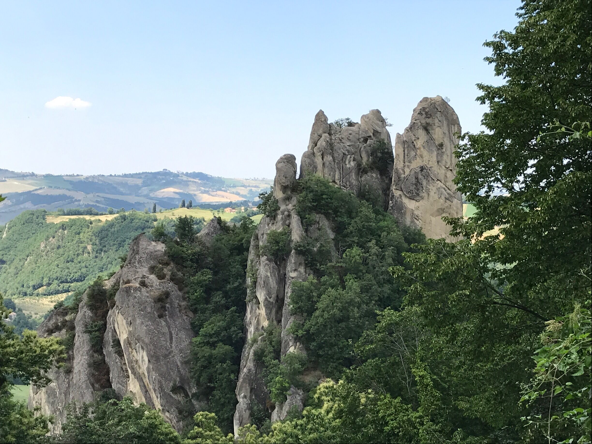 A mountainous landscape with prominent rock formations and dense greenery.
