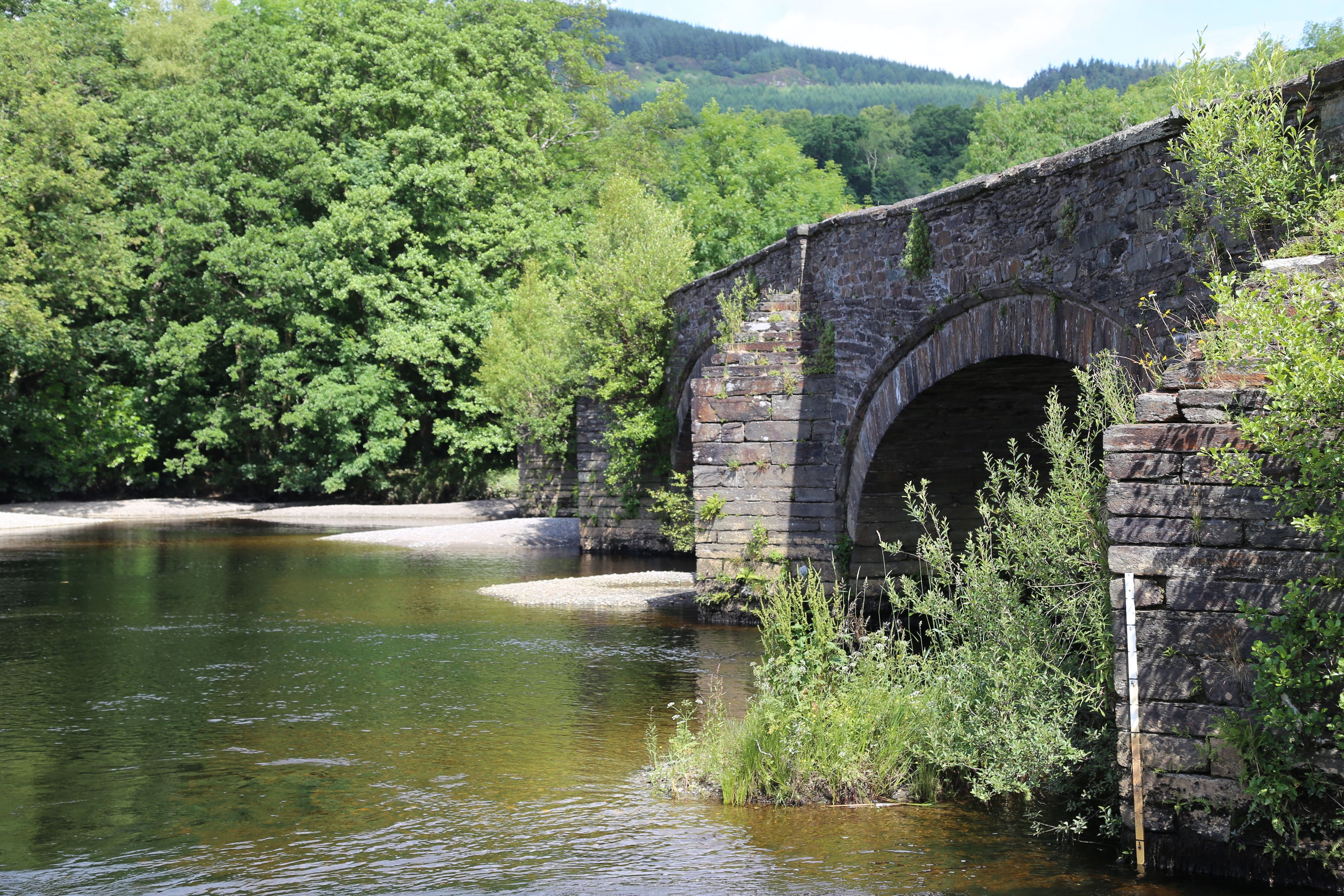 An ancient bridge over the Mawddach River at Llanelltyd, Gwynedd, Wales, UK.