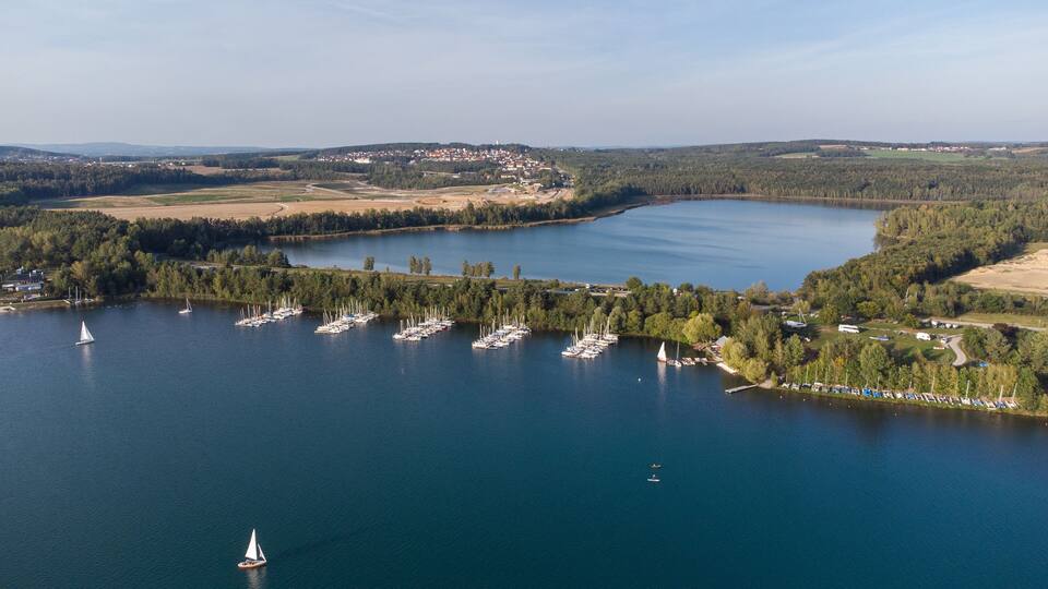 A lake surrounded by forest and a small town.