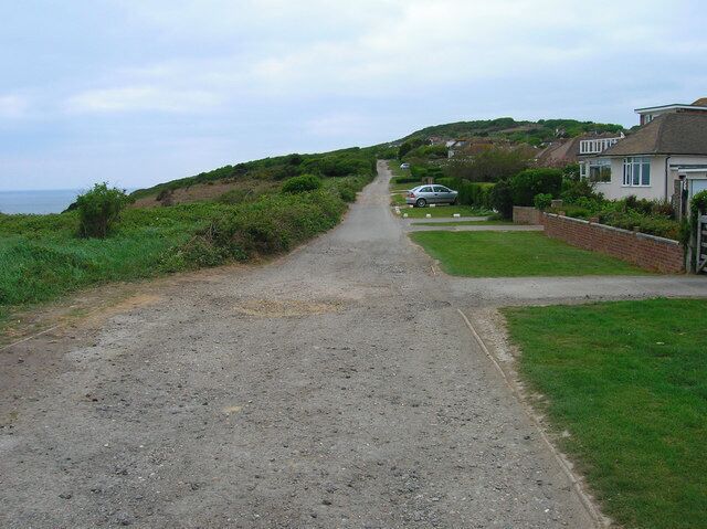 Channel Way, Fairlight Cove An unmade road that marks the boundary of the settlement of Fairlight Cove from the cliff top to the south. The Firehills can be seen in the background. The eastern part of this road has now been closed due to cliff erosion.