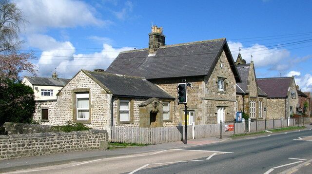 A stone building with a traditional design, a street, and a clear blue sky.