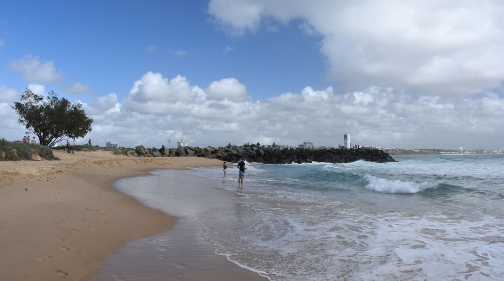 Buddina, Australia - Apr 21, 2019. People relaxing on Buddina Beach breakwall (Sunshine Coast, Queensland, Australia) on a sunny but cloudy day.