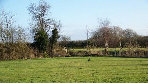 Footpath, Lower Weare The footpath leaves the A38 to cross the area of lawn before joining the footpath beside the River Axe.