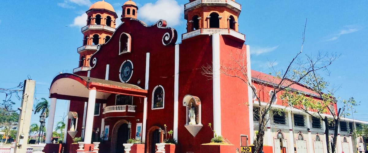 A red church with multiple domes and a clock tower.