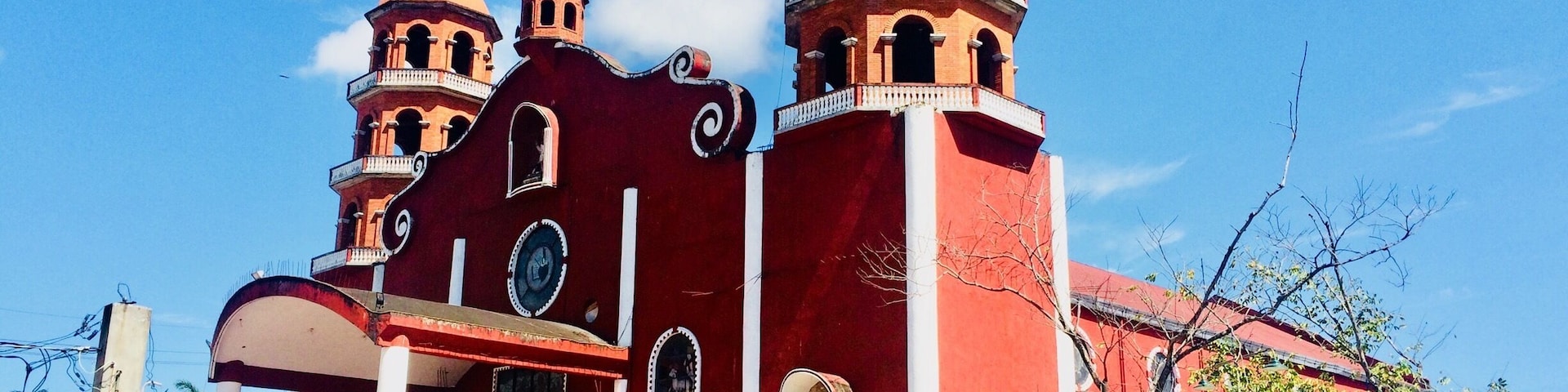 A red church with multiple domes and a clock tower.