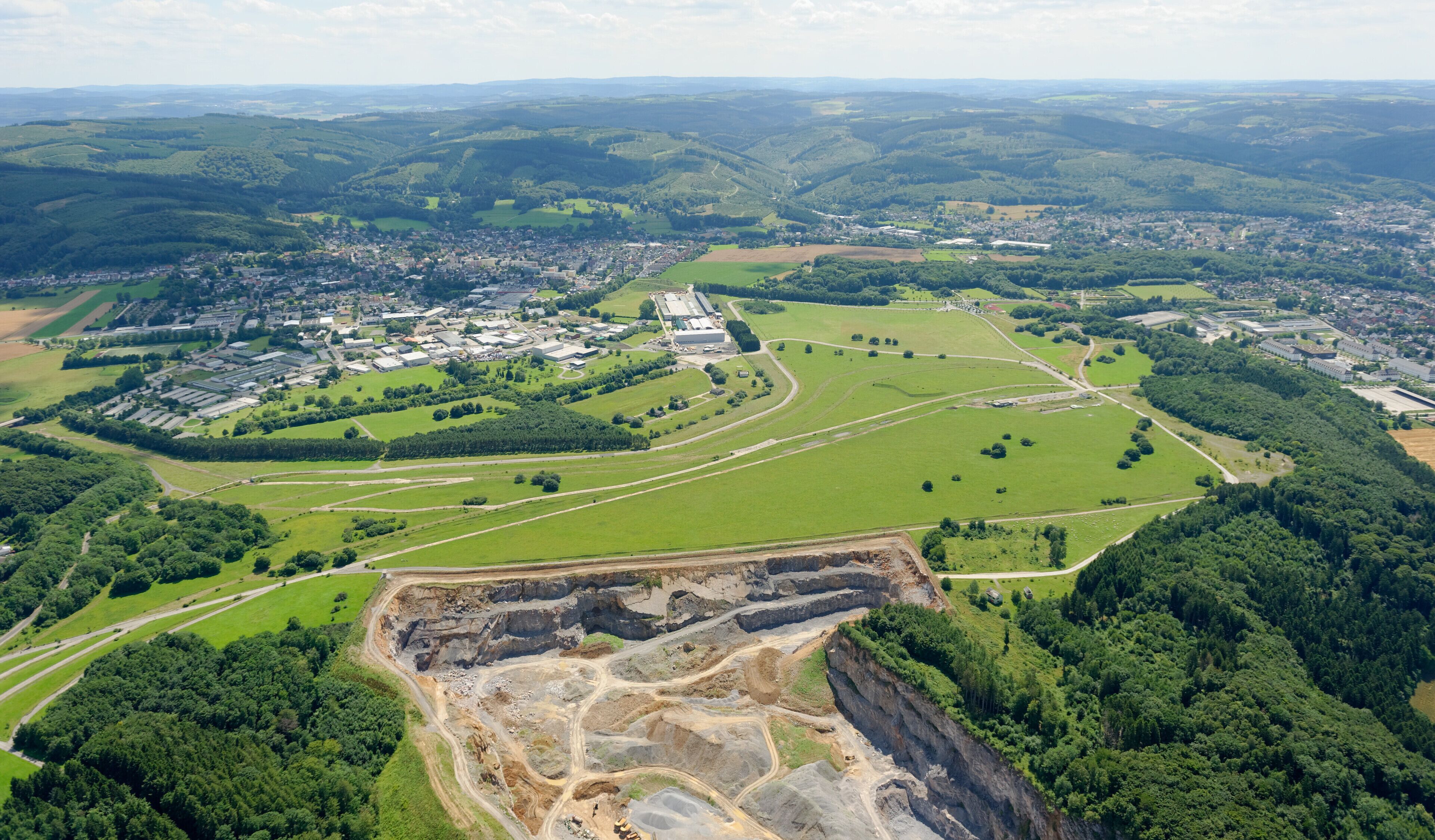 Luftaufnahme: Unten Steinbruch Hemer-Becke, dann Naturerlebnisgebiet Hemer-Apricke der NRW-Stiftung von Süden, ehemaliger Standortübungsplatz nördlich von Deilinghofen, hier westliche Teilfläche mit Panzerstraßen, links Hemer-Deilinghofen und rechts Hemer, Nordrhein-Westfalen