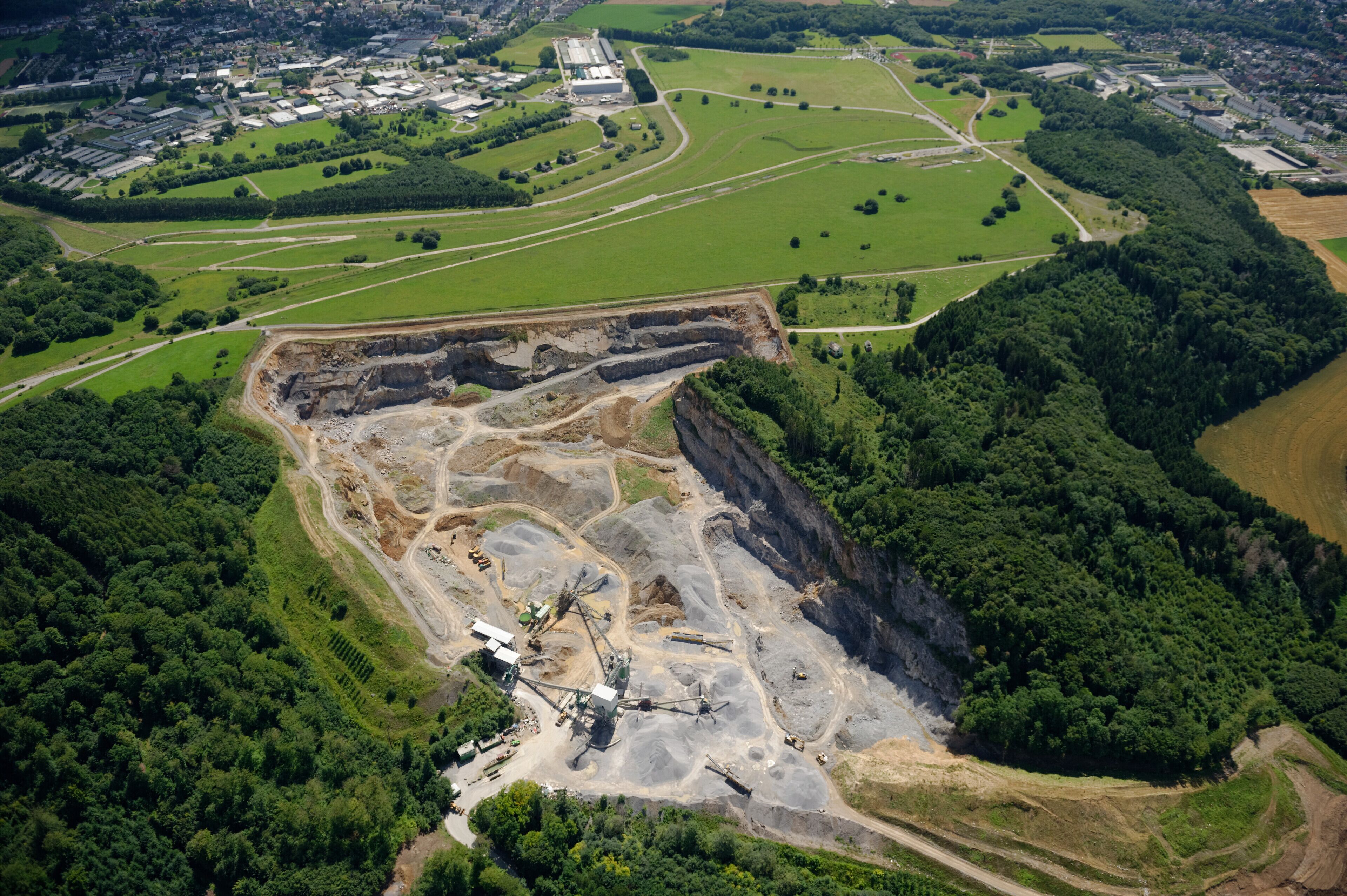 Luftaufnahme: Steinbruch Hemer-Becke, dann Naturerlebnisgebiet Hemer-Apricke der NRW-Stiftung mit ehemaligen Panzerstraßen des Standorttruppenübungsplatzes, links Deilinghofen und rechts Hemer,, Nordrhein-Westfalen