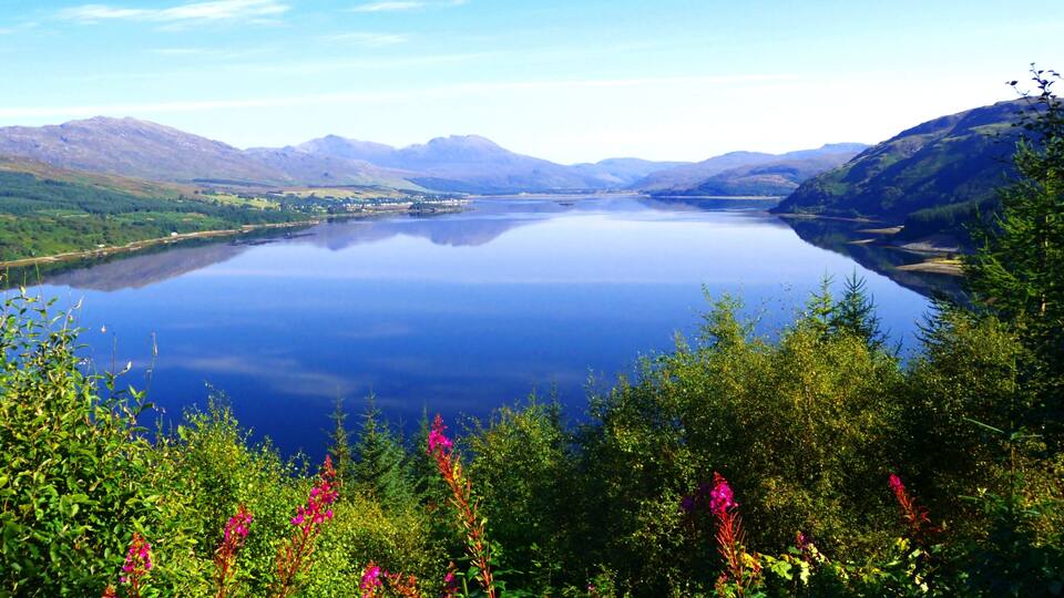 A lake surrounded by mountains and lush greenery.