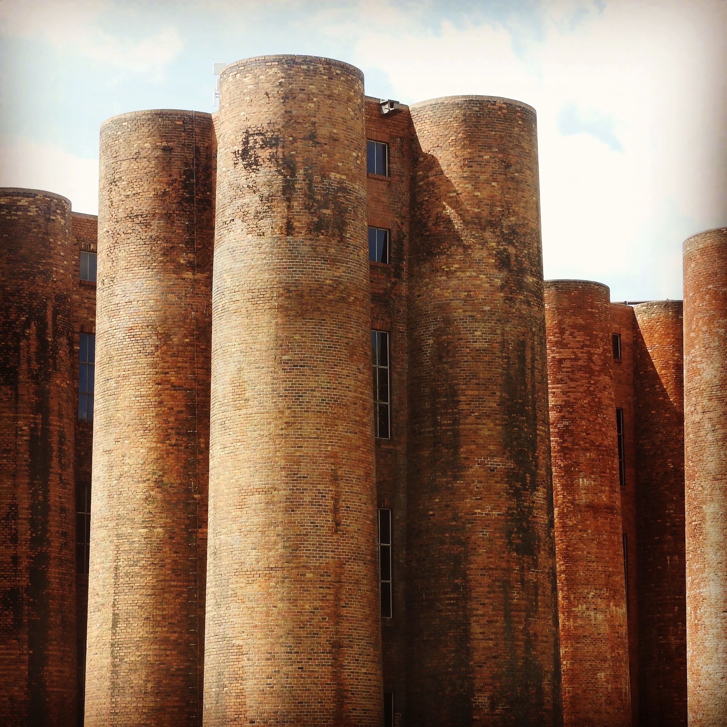 A row of tall brick towers with windows.