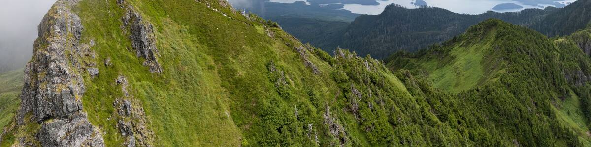 Aerial Panorama of hiker on Ḵuu Jaad Sleeping Beauty with view of Skidegate Inlet