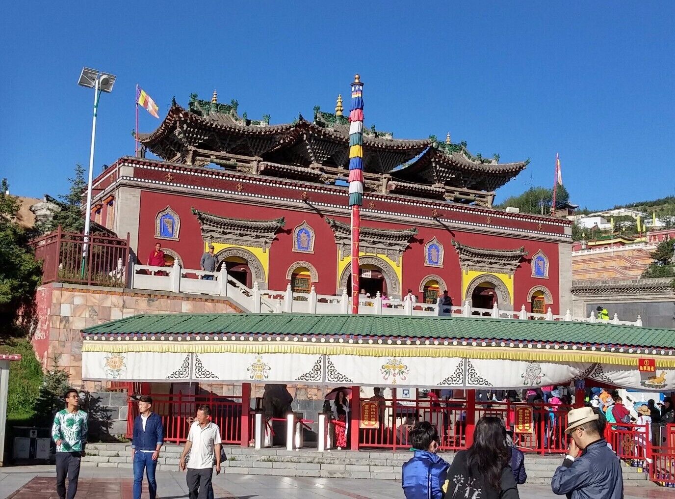 A traditional building with ornate architecture, a red facade, and a green roof.