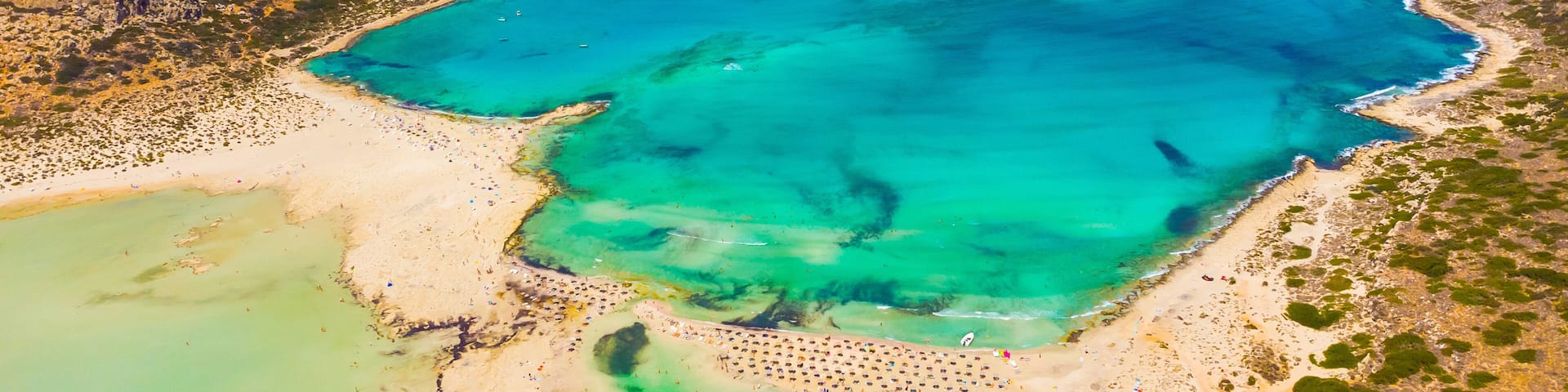A coastal landscape with clear turquoise waters, sandy beaches, and rocky cliffs.