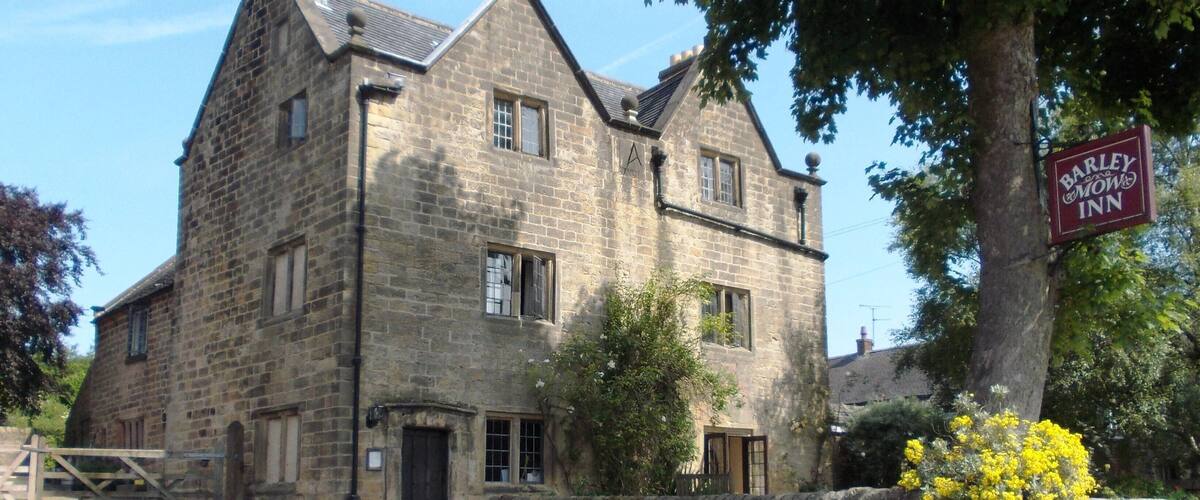 A stone building with a sign for 'Barley Bawley Inn'.